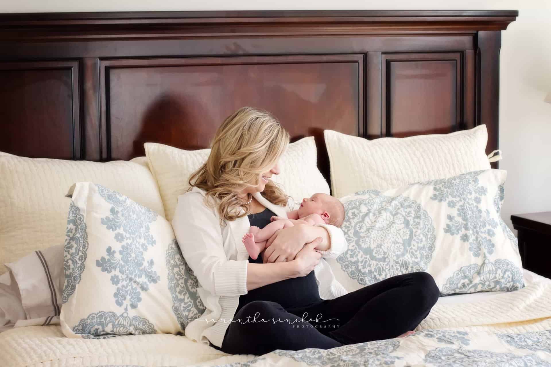 mother looks at newborn daughter during cincinnati newborn pictures