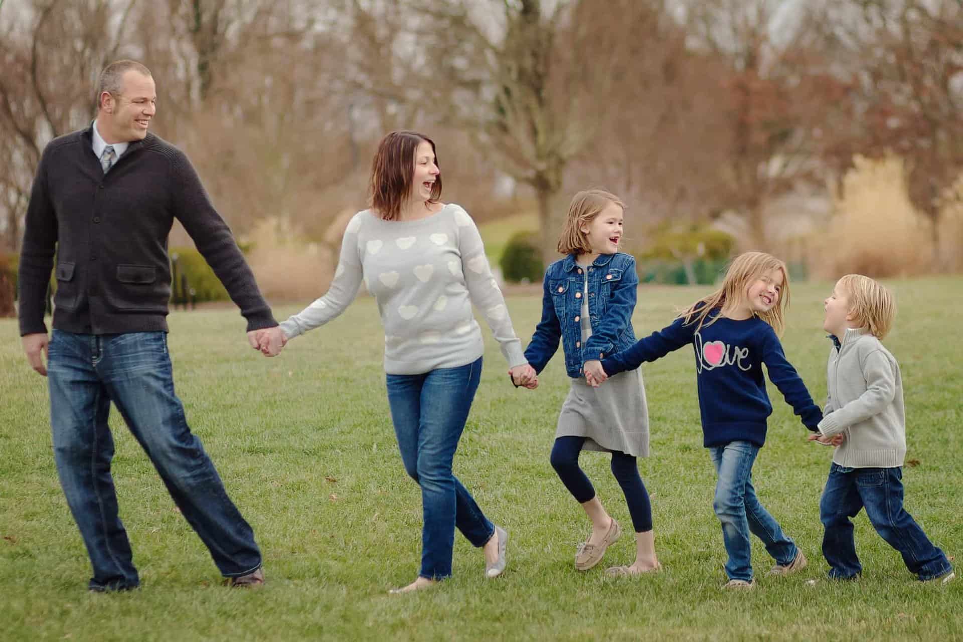 Family walks hand in hand laughing and having fun