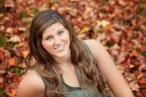 laktoa senior girl sits in a pile of leaves at looks at cincinnati photographer