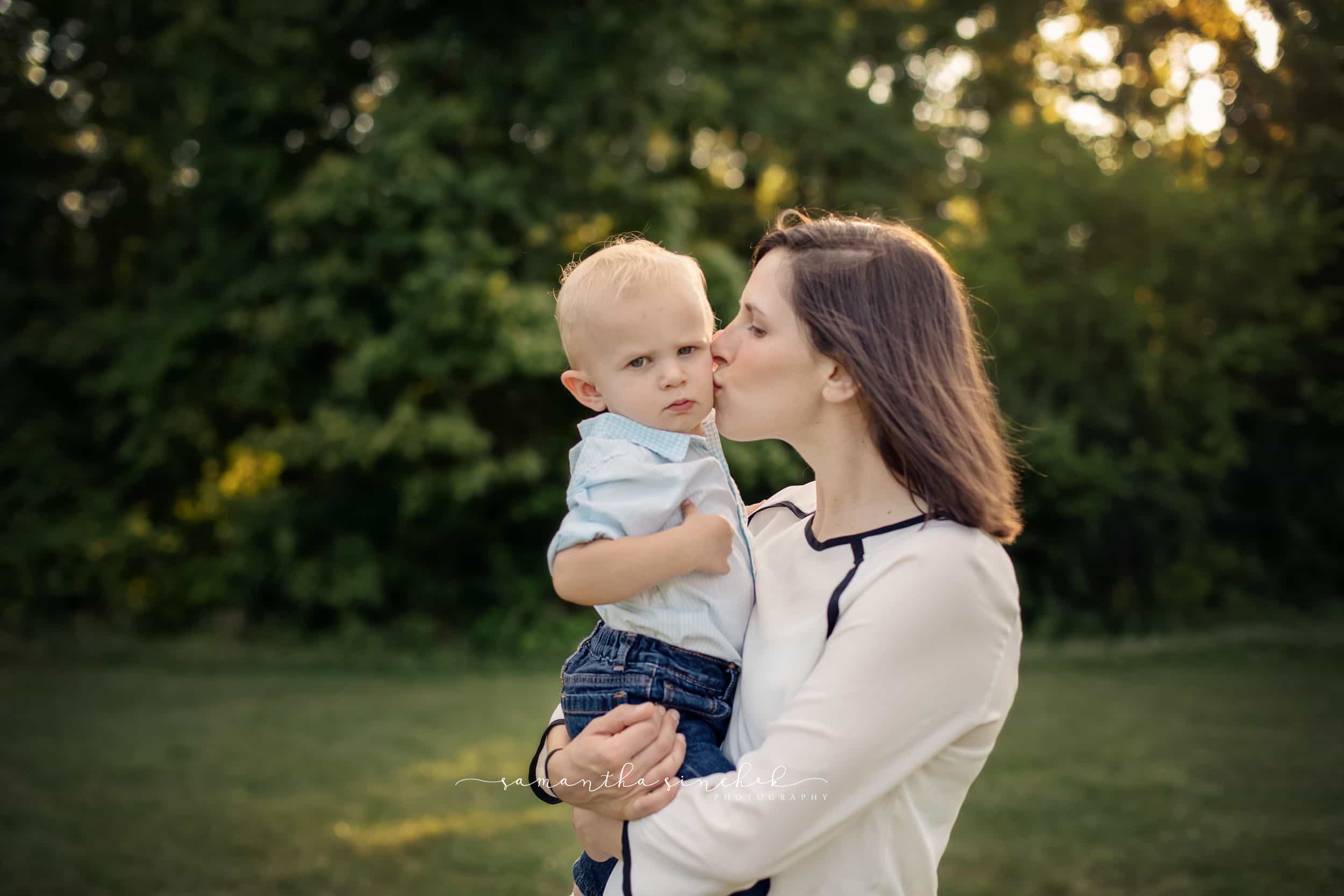 mother kisses son on the cheek at family pictures in sharon woods with samantha sinchek