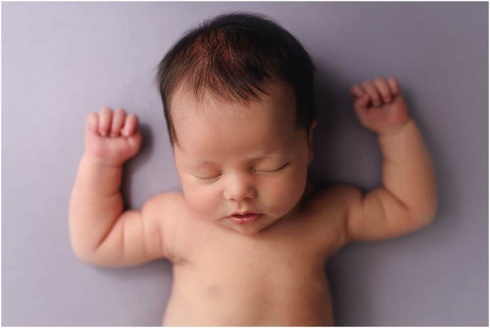 newborn sleeps on lavender background at session with cincinnati newborn photographer Samantha sinchek