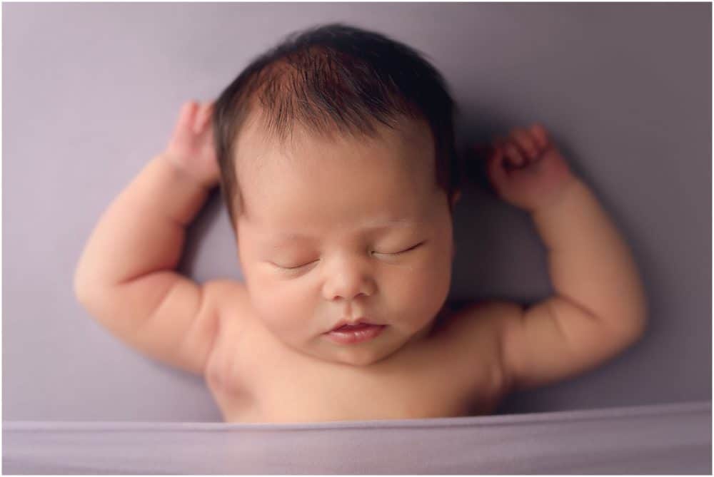 newborn sleeps on lavender background at session with cincinnati newborn photographer Samantha sinchek