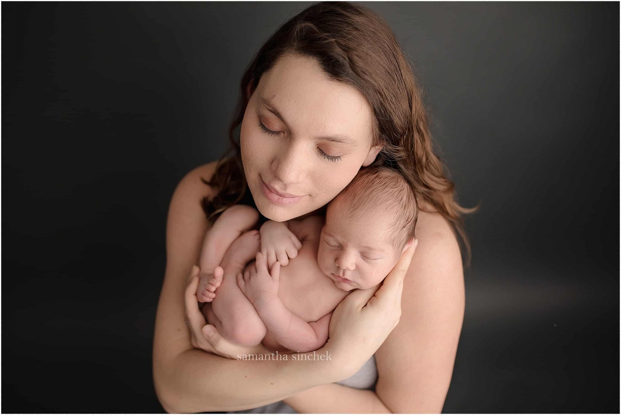 young family holds newborn son at pictures with Cincinnatis premier newborn photographer Samantha sinchek