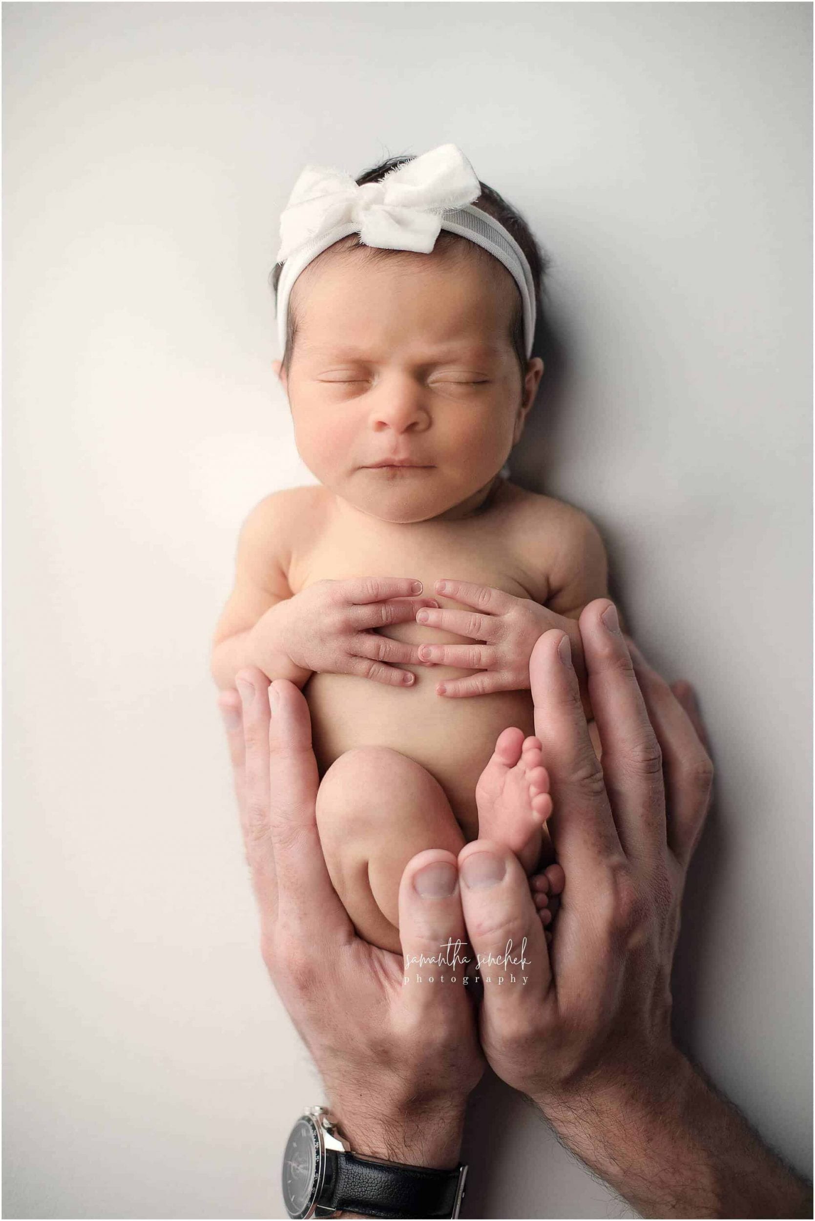 newborn sleeps in dads hands